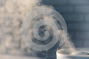 Humidifier spreading steam with white brick wall background