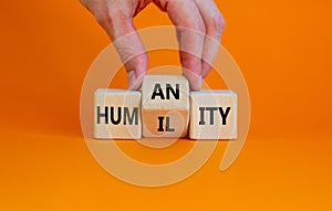 Humility vs humanity symbol. Businessman turns cubes and changes the word `humility` to `humanity`. Beautiful orange table, or