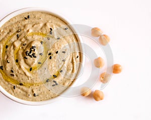 Hummus in a cup with chickpeas isolated on white photo