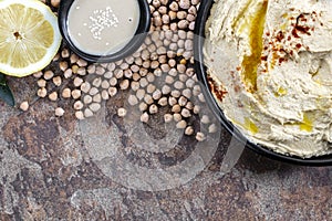 Hummus Dip with Ingredients Top View on Rustic Stone Background
