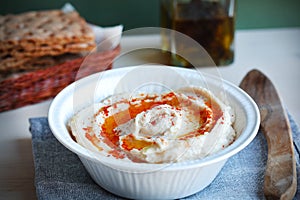 Hummus dip with olive oil and crisp bread basket