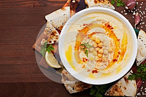 Hummus or houmous, appetizer made of mashed chickpeas, tahini, lemon, garlic, olive oil, parsley and paprika