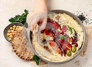 Hummus. Large bowl of homemade hummus garnished with chickpeas, vegetables and olive oil. Middle east food