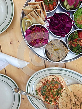 Hummus and Middle Eastern salads on a restaurant table photo