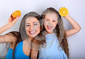 Humor laughing young mother and cute long hair daughter holding