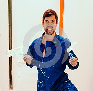 Humor at work. Funny man, crazy house painter with roller and brush. Crazy expression