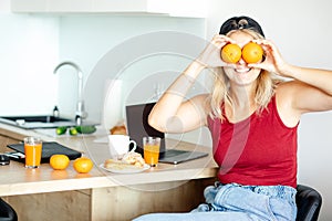 Humor. Young blonde is having fun at home in kitchen during breakfast with orange juice and fresh pastries, .