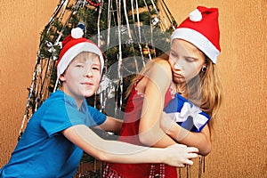 Humorous dispute over a gift box near a decorated Christmas tree