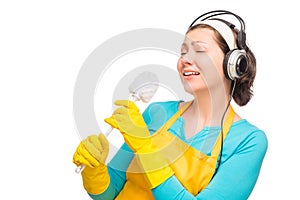 Humorous photo housewife with headphones and a cleaning brush