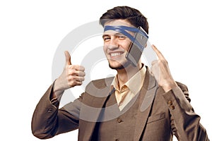 A humorous photo of modern technologies. Young guy with a phone attached to the head using a tape