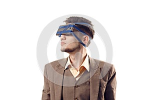 A humorous photo of modern technologies. Young guy with a phone attached to the head using a tape. Virtual reality gadget
