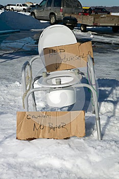 Humorous portable toilet seat in snowy terrain