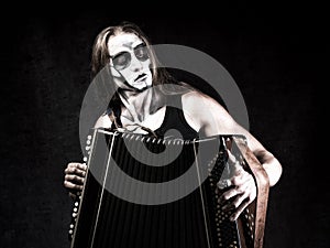 Humorous portrait of man in goth style clothes and scull makeup.