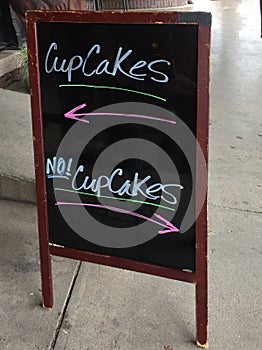 A humorous sign indicating which way to go for cupcakes