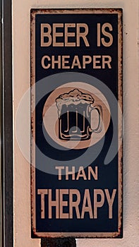 Humorous sign stating that `Beer is cheaper than therapy on a wall in a restaurant in Portugal.