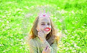 Humour queen concept. Girl sits on grass at grassplot, green background. Girl on cheerful face spend leisure outdoors