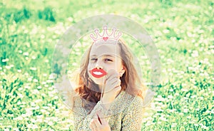 Humour queen concept. Girl sits on grass at grassplot, green background. Girl on cheerful face spend leisure outdoors