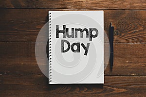 HUMP DAY text written in an office notebook on a wooden table