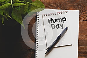 HUMP DAY text written in an office notebook on a wooden table