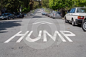 Hump speedbump and arrow on asphalt pavement along residential street in neightborhood