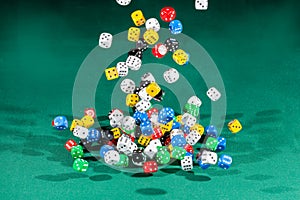 Hundred colored dices falling on a green table