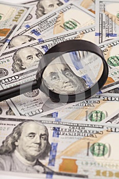 Hundred dollar banknotes under magnifying glass