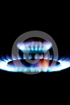 a hundred dollar bill on a gas burner with a burning fire on a black background, the front and back background is blurred with a
