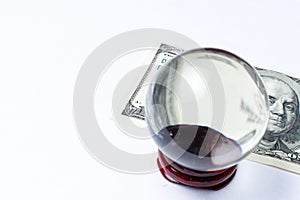 Hundred dollar bill under a magnifying glass ball is being inspected Conceptual photo isolated on white background