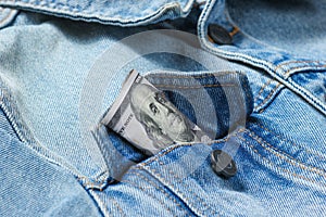 Hundred-dollar bill in your jeans jacket pocket close-up, macro photo.