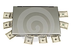 Hundred-dollar bills lying on laptop