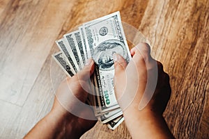 Hundred dollar bills on a wooden background