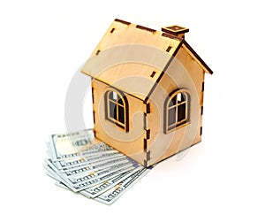 Hundred-dollar bills and wooden toy house