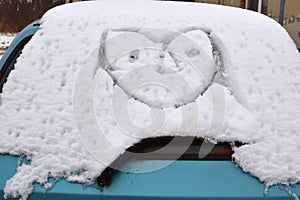 Drawing a funny face on a car. photo