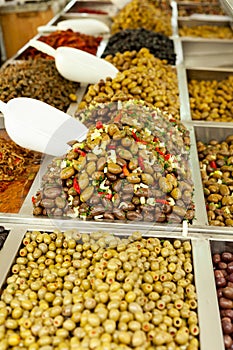 Hundreds of traditional Italian green olives, multiple types. Huge olive heap at a local market stall Stack of different olives