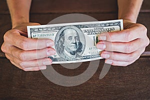 Hundres dollars - two hands holding 100 dollar bill cash