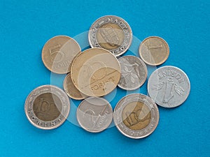 Hungarian forint coins under magnifying glass on a blue background. Local currencies