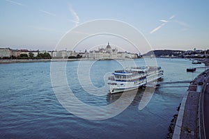 Hungarian Parliament Building by the Danube River in the evening behind a big ship in the port