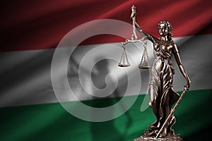 Hungary flag with statue of lady justice and judicial scales in dark room. Concept of judgement and punishment