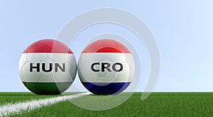 Hungary vs. Croatia Soccer Match - Soccer balls in Hungarys and Croatias national colors on a soccer field. photo