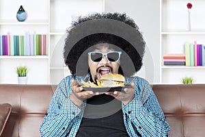 Hungry Afro man eats cheeseburger