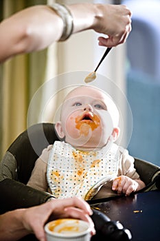 Hungry baby eating solid food from a spoon