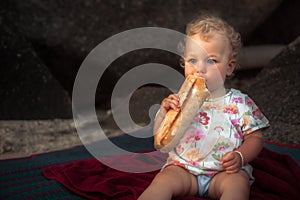 Hungry baby girl eating baguette bread countryside rustic lifestyle copy space