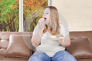 Hungry blonde woman eats donuts