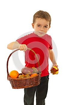 Hungry boy with fruits in basket