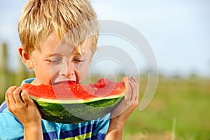 Hungry boy with watermelon outdoors