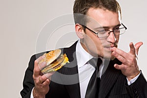 Hungry businessman eating hamburger