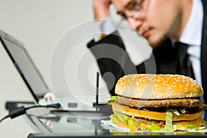 Hungry businessman eating hamburger