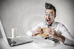 Hungry businessman working during lunch break