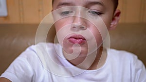 Hungry Caucasian Teen Puts Croutons in Mouth with Hand. Boy Eats Fast Food.