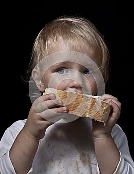 Hungry child eating bread